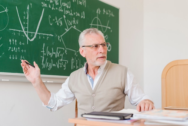 Antiguo profesor explicando en aula | Foto Gratis