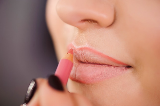 Aplicando contorno de labios. primer plano de cara de mujer. cosméticos de  belleza, concepto de maquillaje. | Foto Premium
