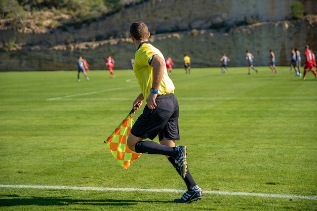 Árbitro asistente en un partido de fútbol viendo el partido | Foto Premium
