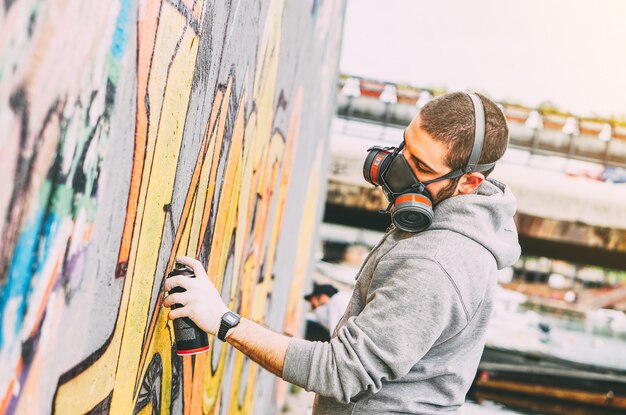 Artista Callejero Pintando Coloridos Graffiti En Una Pared Debajo Del