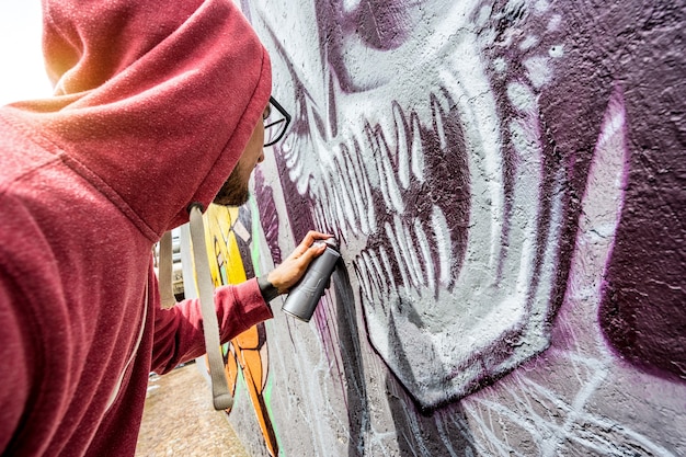 Artista Callejero Pintando Coloridos Graffiti En La Pared Pública