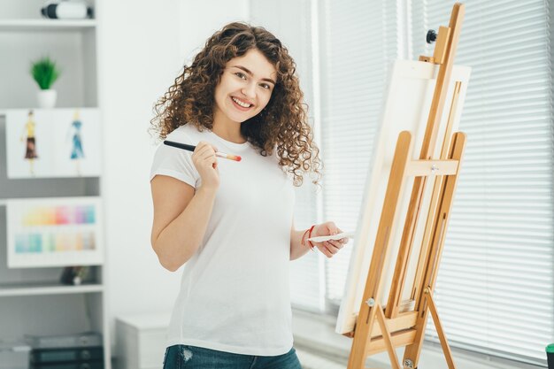 El Artista Feliz Pintando Un Cuadro En El Caballete Foto Premium