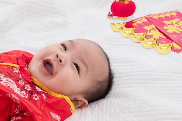 Asiatico Lindo Bebe Nino Chino Cheongsam Disfraz Nino Acostado En La Cama En Casa Con Lingotes