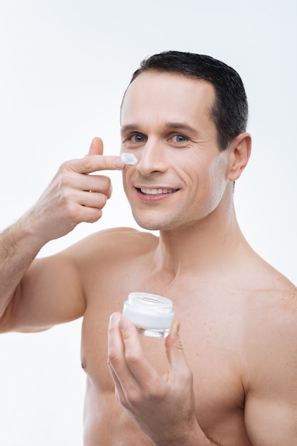 Aspecto Perfecto Hombre Alegre Positivo Sonriendo Y Usando Crema Facial Mientras Se Preocupa