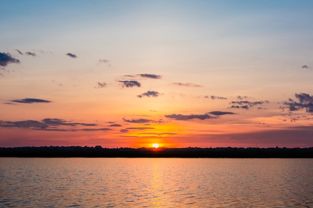 Atardecer en el lago hermosa puesta de sol detrás de las nubes sobre