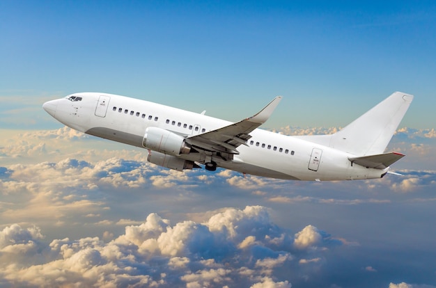 Avión de pasajeros vuela en el cielo ganando altura sobre las nubes