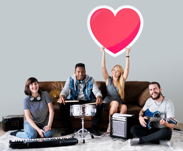 Banda de músicos sosteniendo un emoticono de corazón. Foto gratis