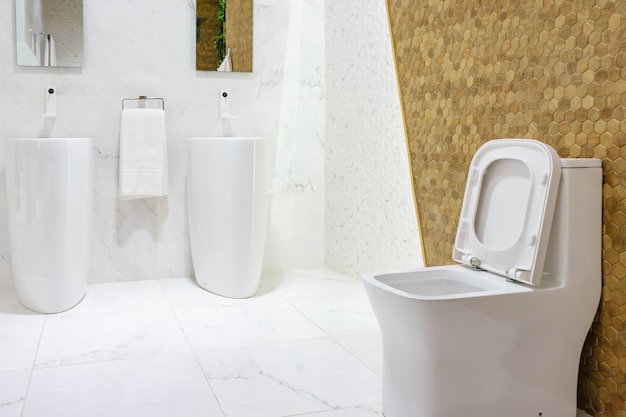 Baño amplio y moderno con azulejos brillantes con inodoro y lavabo