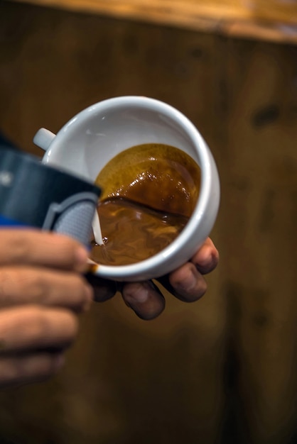 Barista vertiendo espuma de latte para hacer un café con