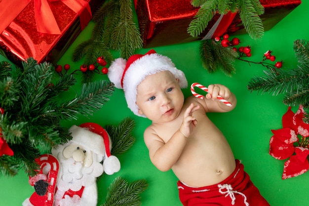 Un Bebe De 6 Meses En Un Traje De Papa Noel Yace En Un Green Foto Premium