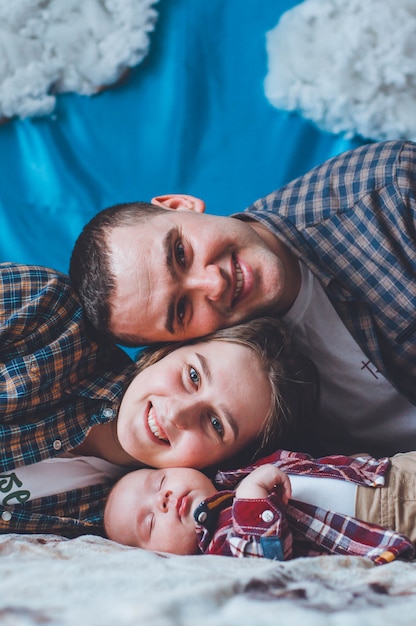 Bebe En Una Camisa A Cuadros Con Papa Y Mama Bebe Y Sus Padres Foto De Familia Apoyarse En Las Mejillas Del Otro Foto Premium