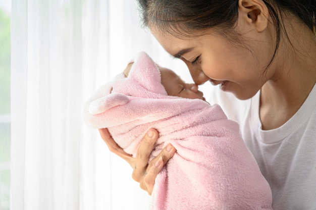 Bebé recién nacido durmiendo en manos de la madre y la nariz chocó Foto gratis