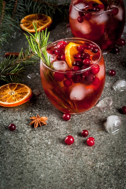 Bebidas Navidenas De Invierno Coctel Frio Con Arandanos Naranja Romero Con Especias Canela Anis Y Hielo Sobre Una Mesa De Piedra Oscura Copyspace Foto Premium