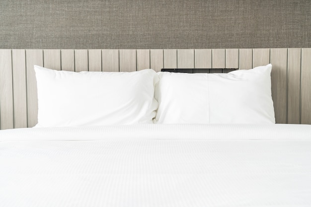 Blanco almohada en la decoración de la cama en el dormitorio Foto gratis