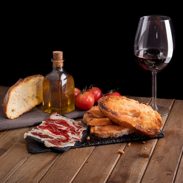 Bodegón De Jamón Ibérico Con Pan De Tomate En Bandeja De Piedra Pizarra Y Copa De Vino Fondo 0631