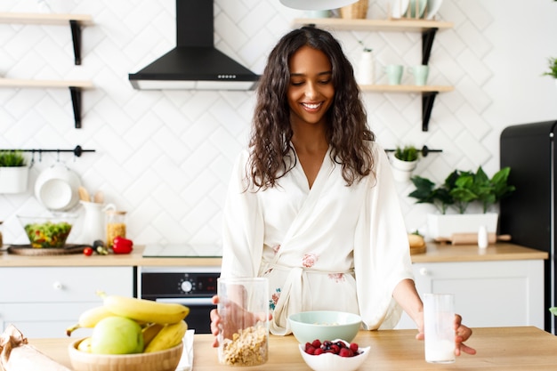 Bonita mujer africana está haciendo un desayuno saludable Foto gratis