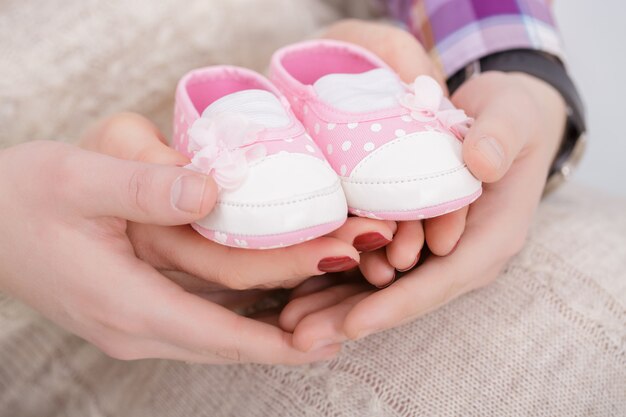 Botines Rosados Para Bebe Recien Nacido En Manos De Mama Y Papa El Embarazo Foto Premium