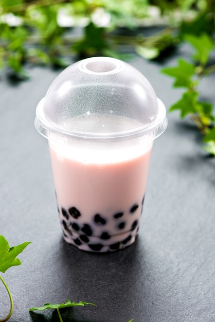 Burbuja de té de boba con leche y perlas de tapioca en vaso de plástico