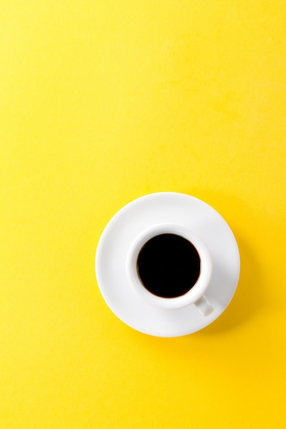 Café espresso en pequeña taza de cerámica blanca sobre fondo vibrante