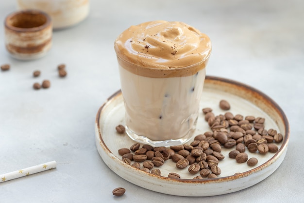 Café con espuma dulce y hielo en un vaso. | Foto Premium
