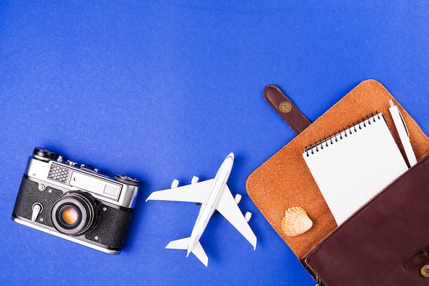 Cámara retro cerca de avión de juguete y estuche con libreta Foto gratis