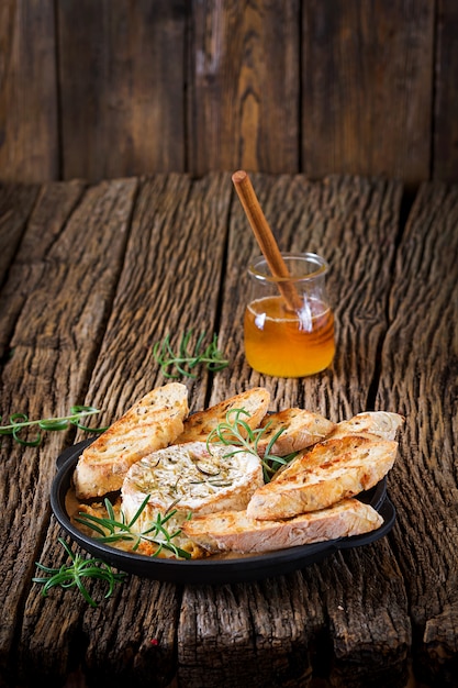 Camembert de queso al horno con romero y miel. comida sabrosa. | Foto Premium