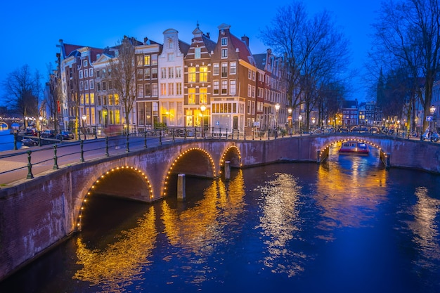 Canales de amsterdam con edificios holandeses en la noche en la ciudad