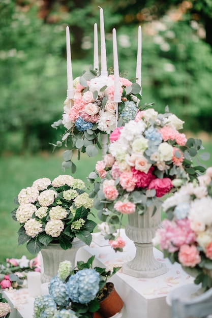 Candelabros y floreros con bellas flores en colores pastel ...