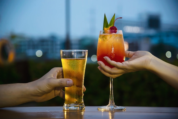 Celebración de pareja en restaurante con refrescos cerveza y mai tai o mai thai Foto gratis