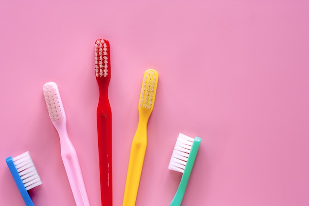 Cepillo de dientes utilizado para limpiar los dientes sobre fondo rosa