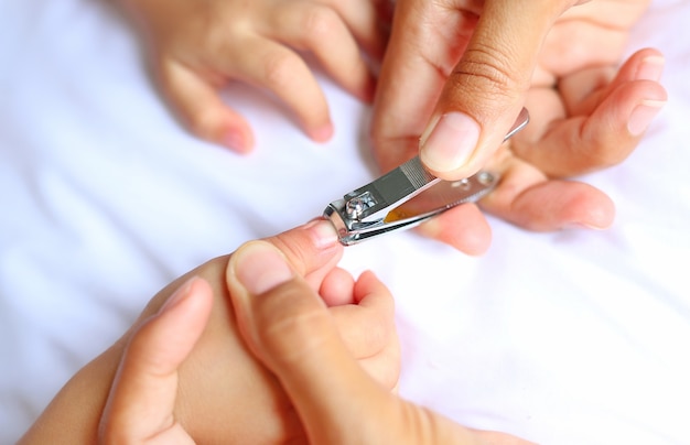Cerca de mamá cortando las uñas de los bebés | Foto Premium
