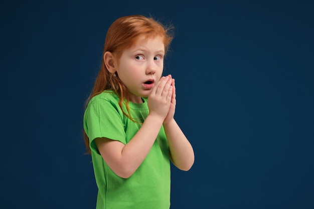 Cerrar Foto De Niña Emocional Pelirroja Posando Ante La Cámara Sobre Fondo Azul Foto Premium