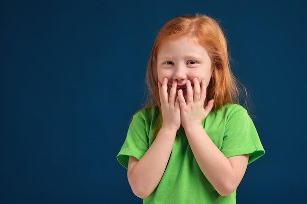 Cerrar Foto De Niña Emocional Pelirroja Posando Ante La Cámara Sobre Fondo Azul Foto Premium