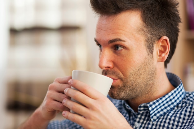 Cerrar hombre tomando café en casa Foto gratis