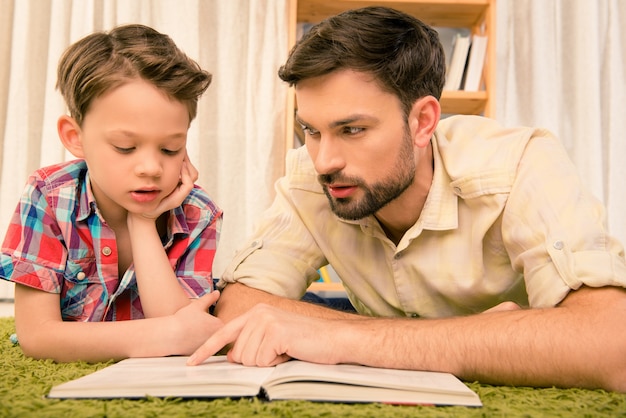 cerrar retrato de padre enseñando a su hijo a leer el libro foto premium