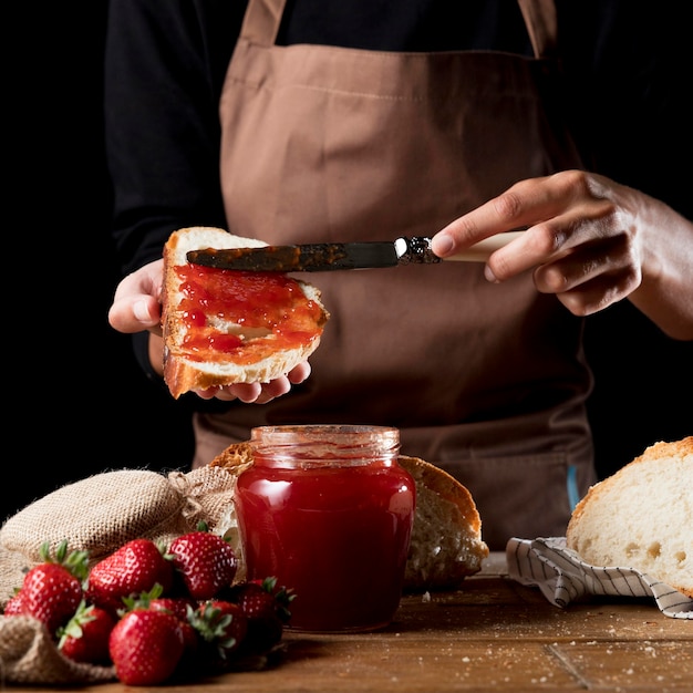 Chef extendiendo mermelada de fresa en la raza Foto gratis