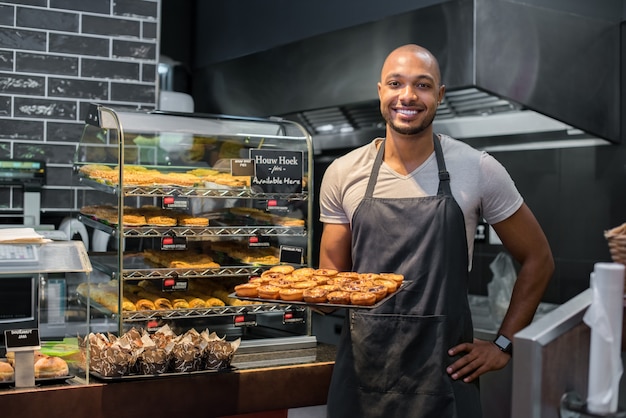 Chef pastelero con pastelería pequeña | Foto Premium