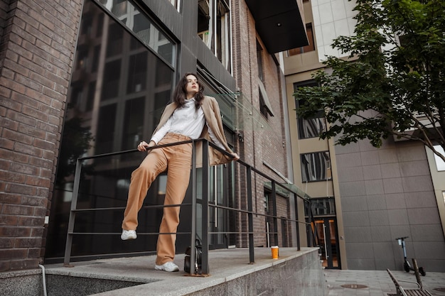 Chica alta y elegante con chaqueta de gran tamaño posando cerca de la