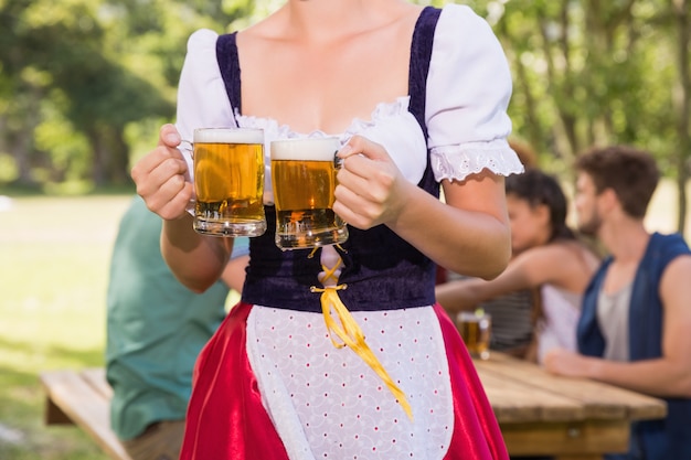 chica-bonita-de-oktoberfest-sosteniendo-jarras-de-cerveza_-