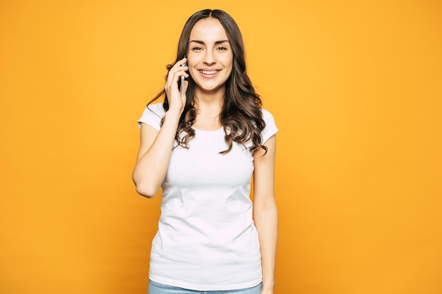 Chica Guapa En Traje Casual De Camiseta Y Jeans Está Hablando Con Su Novio Por Teléfono Móvil 