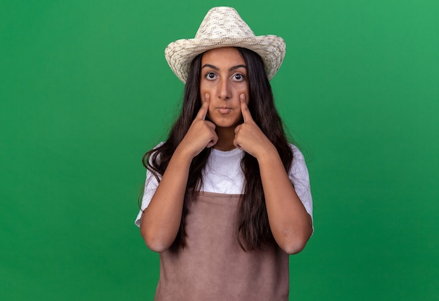 Chica Joven Jardinero En Delantal Y Sombrero De Verano Sorprendido