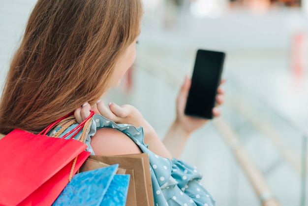 Chica De Lado Sosteniendo Su Teléfono Foto Gratis 