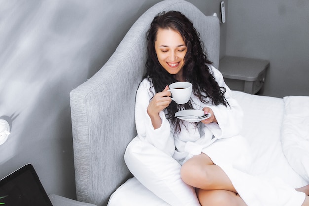 Chica Está Tomando Café En La Cama Mujer En Una Cama Blanca Con Una Taza Foto Premium 