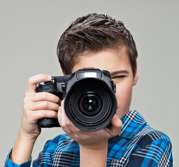 Chico con cámara réflex digital fotografiando. muchacho adolescente con cámara tomando fotografías. Foto gratis