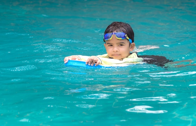 Chico guapo aprendiendo a nadar en la piscina | Foto Premium