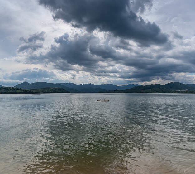 El cielo está cubierto de nubes y hay olas en el agua Foto Premium