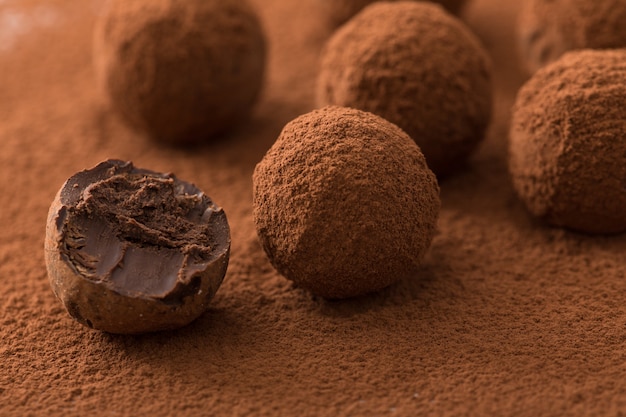 Ciérrese para arriba del grupo de trufas de chocolate negras apetitosas cubiertas en polvo del cacao. Foto Premium