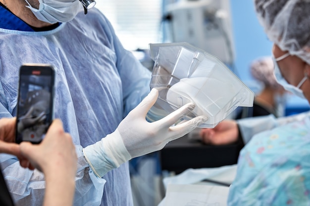 Cirujanos Durante La Cirugía Con Implantes Mamarios En Sus Manos