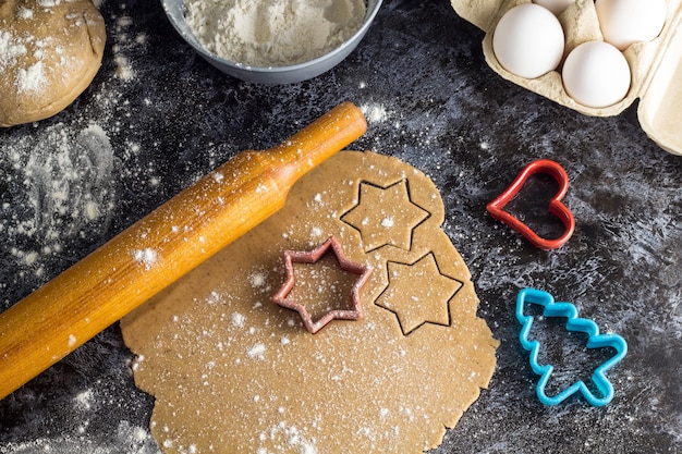 Cocinar Galletas De Jengibre De Navidad Con Ingredientes Sobre Un Fondo Oscuro Foto Premium