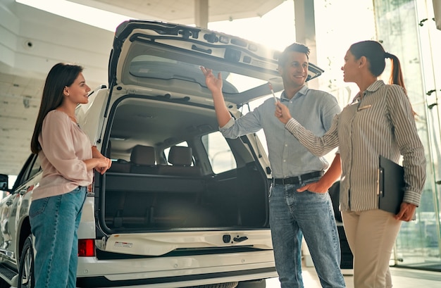 Comprando Su Primer Auto Juntos Vendedora De Automóviles Joven De Pie En El Concesionario 